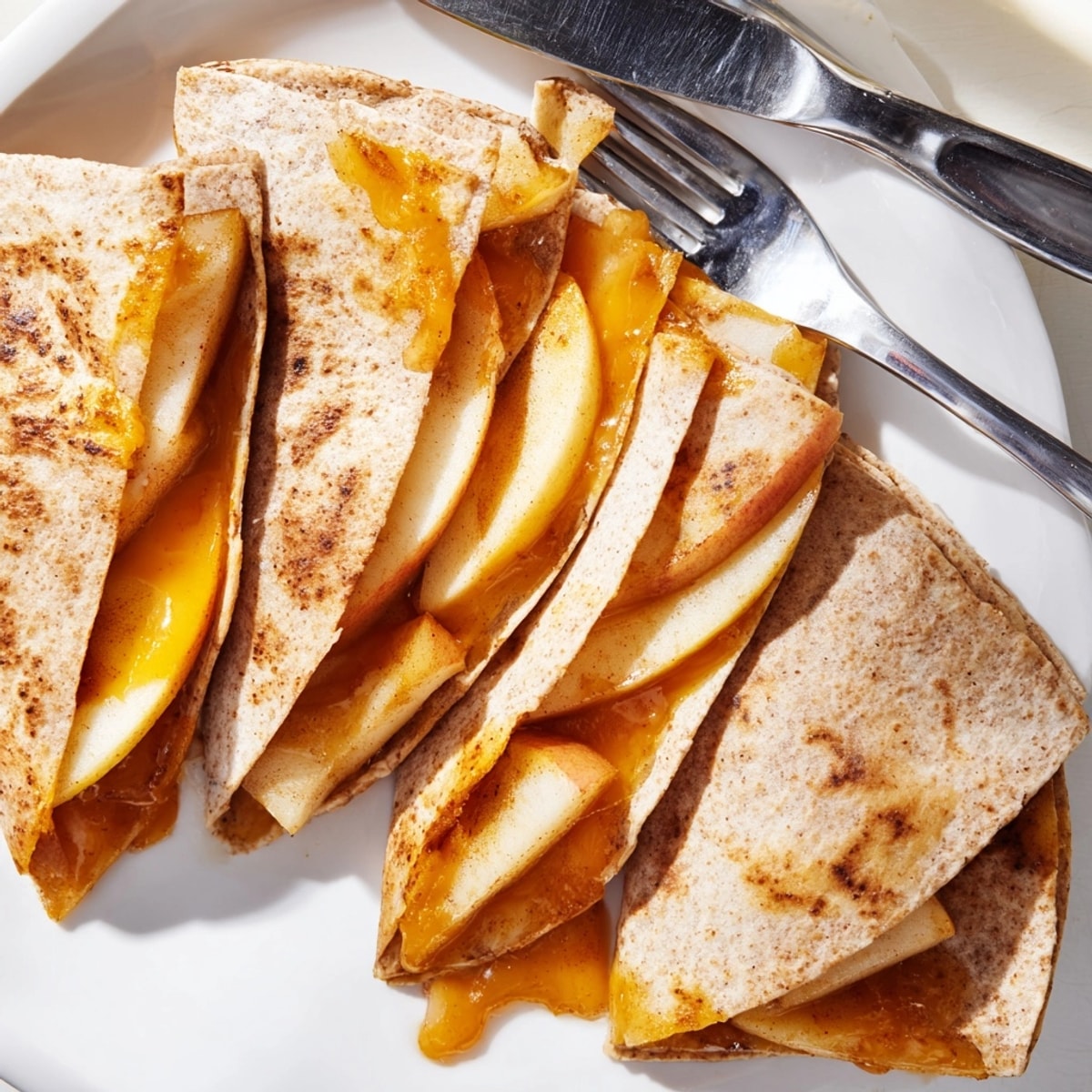 Easy Cheddar Apple Quesadillas recipe: enjoy these crispy wedges with a dollop of honey.