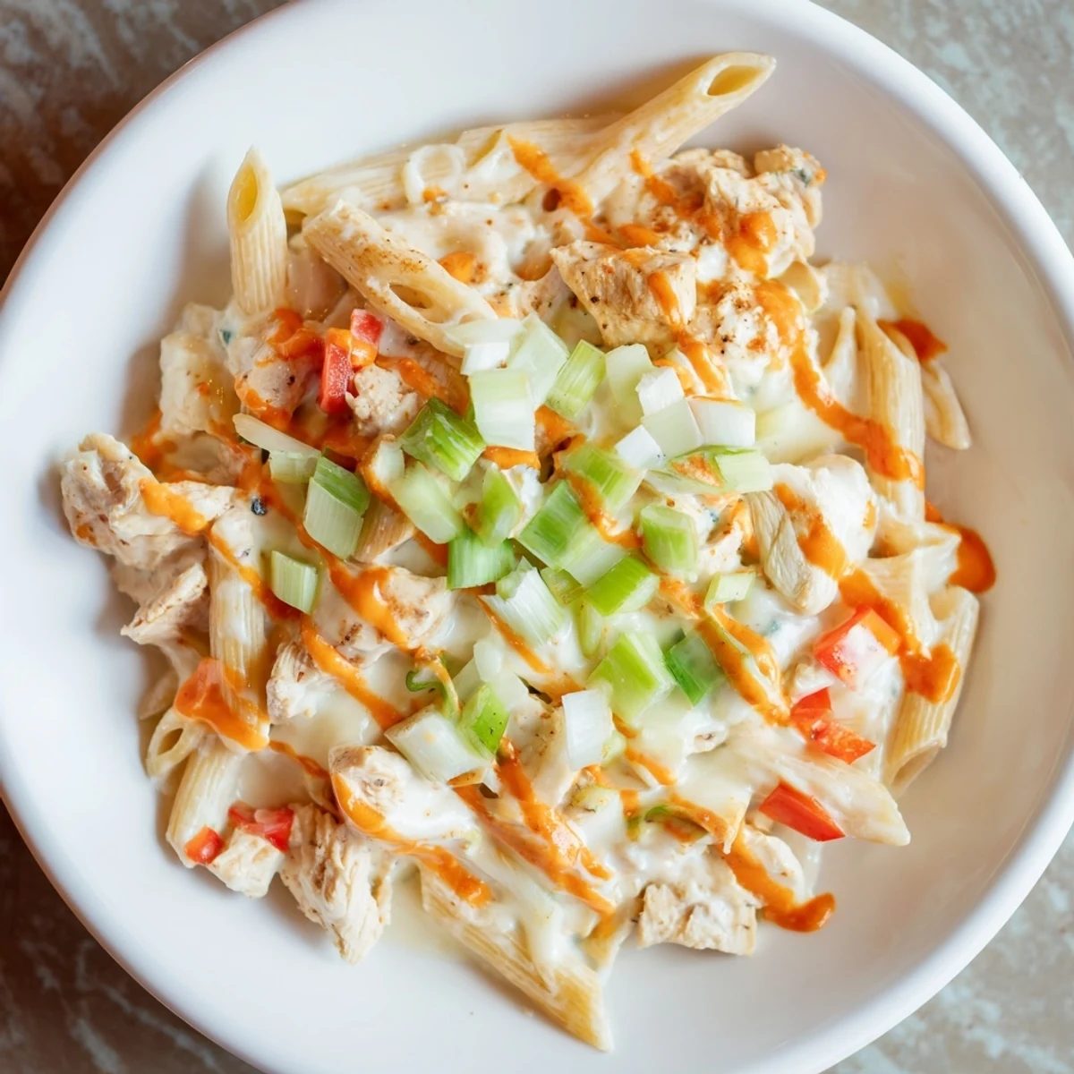 Creamy Buffalo Chicken Pasta Skillet, bubbling hot, with melted cheese and fresh green onions.