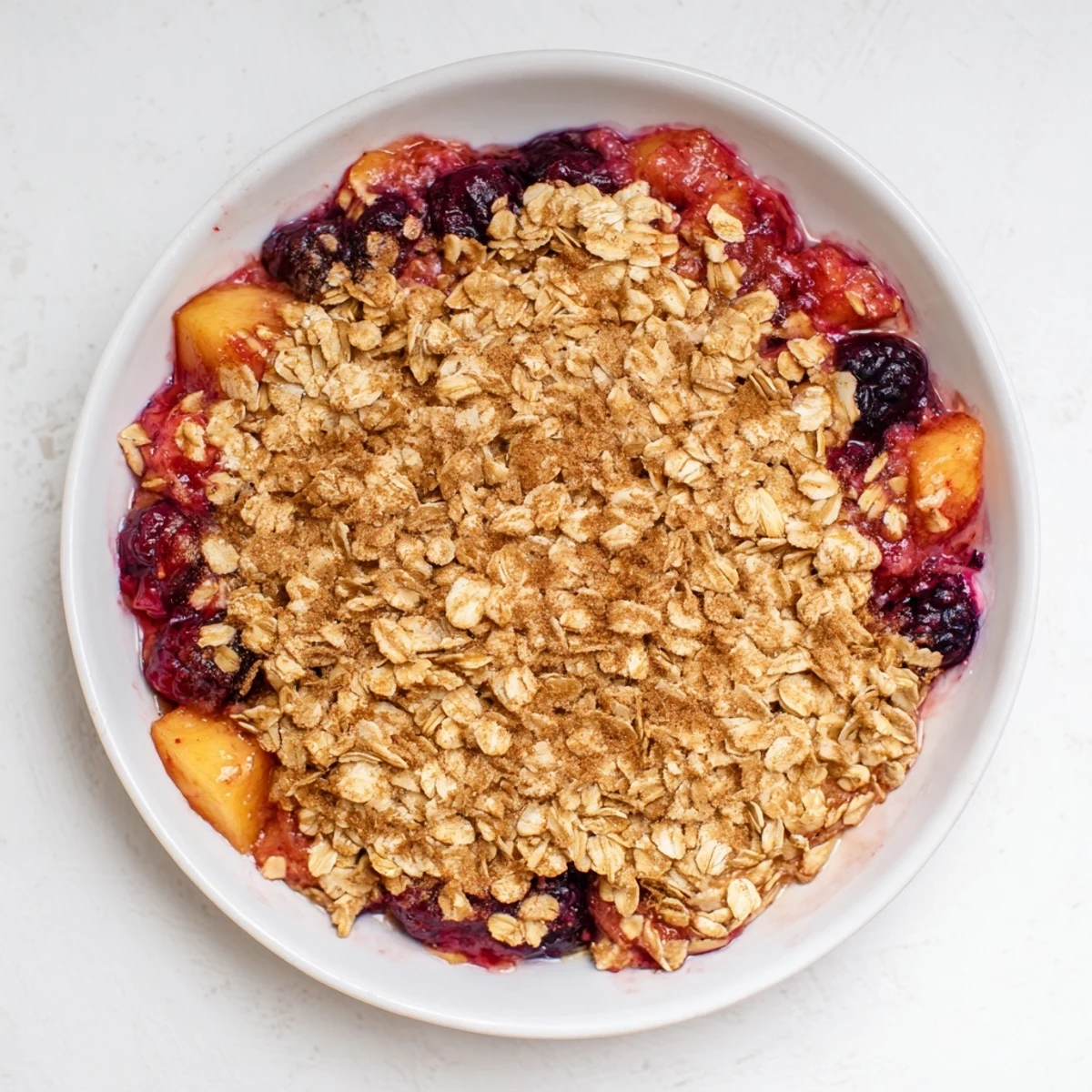 Homemade Fruit Crisp with tender, frozen fruit inside, ready to be served warm with cool vanilla ice cream.