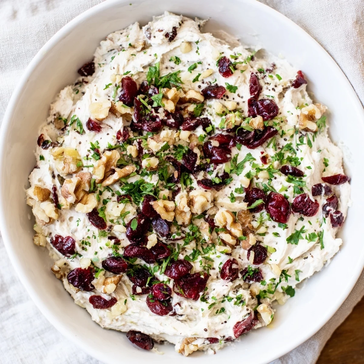 Close-up of Lightened Holiday Cream Cheese Dip, showing a creamy texture with cranberry swirls on top.