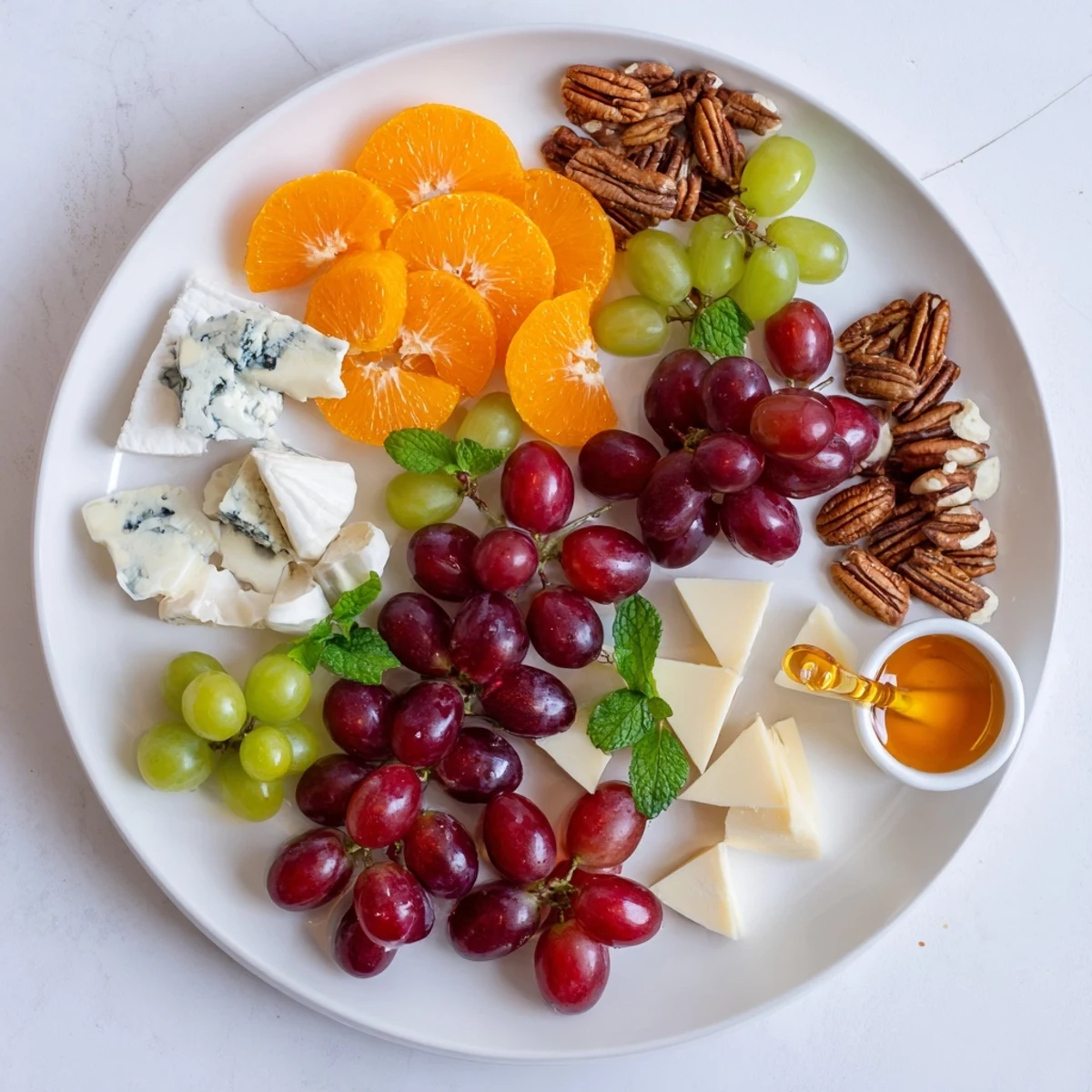 Arranging a Grapes of Fortune Dessert Board with luscious brie and manchego, perfect for New Year's Eve.