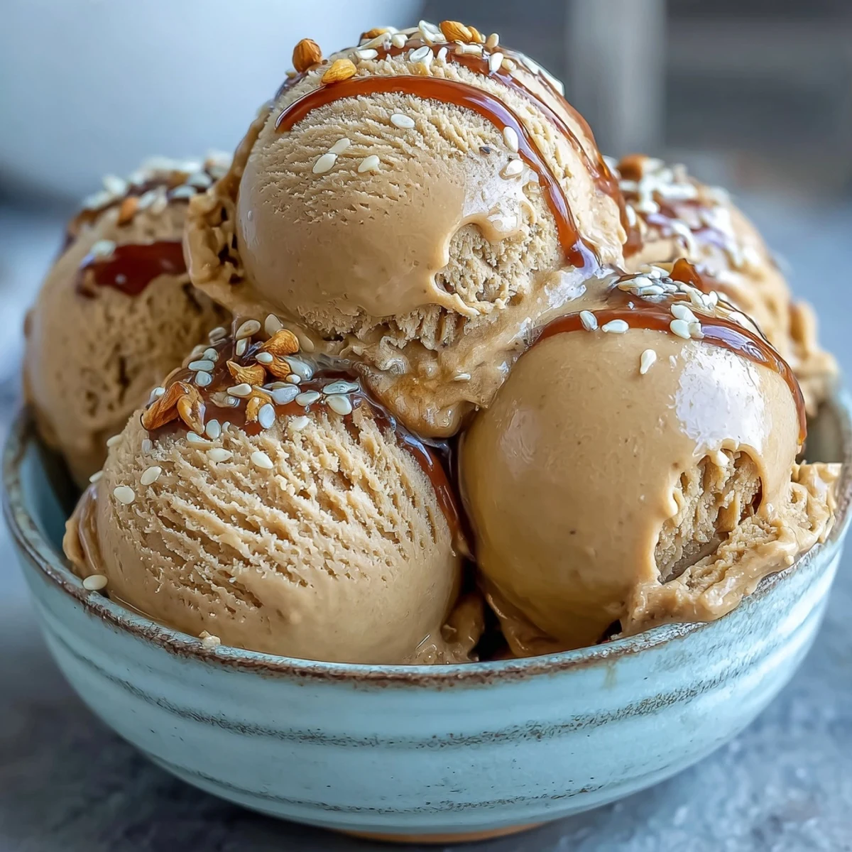 Elegant scoop of Hojicha Ice Cream served on a chilled plate, garnished with a delicate tea leaf.