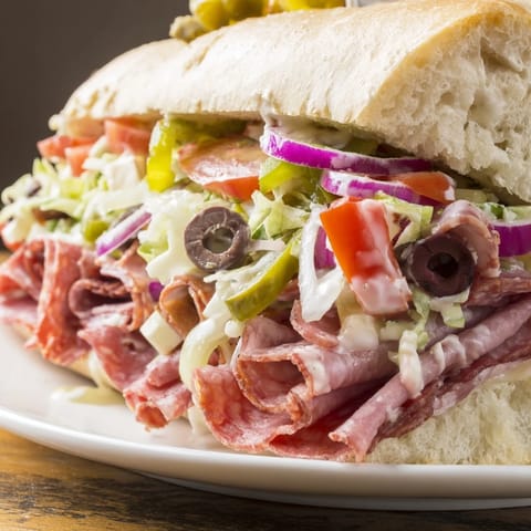 Close-up of Flavor Mash-Up Sandwiches drizzled with creamy dressing on crusty rolls.  