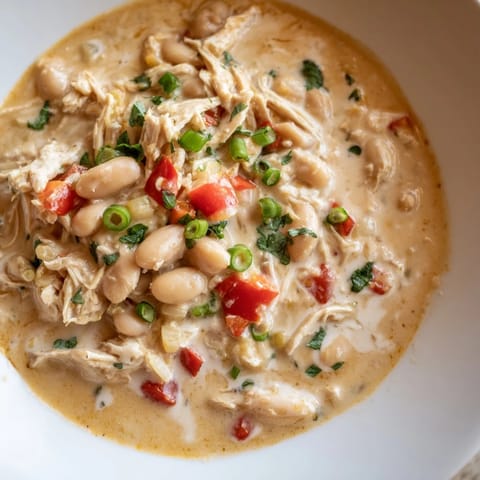 Close-up of hearty Creamy White Chicken Chili with beans, showing tender chicken and creamy sauce.