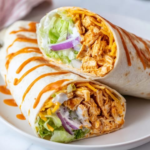 Flaky flour tortilla wrapped tightly around a spicy buffalo chicken filling, drizzled with creamy ranch and topped with fresh chopped romaine lettuce.