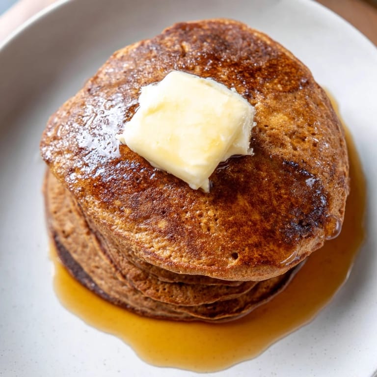 Warm gingerbread pancakes stacked high, evoking the cozy flavors of Christmas morning with butter.