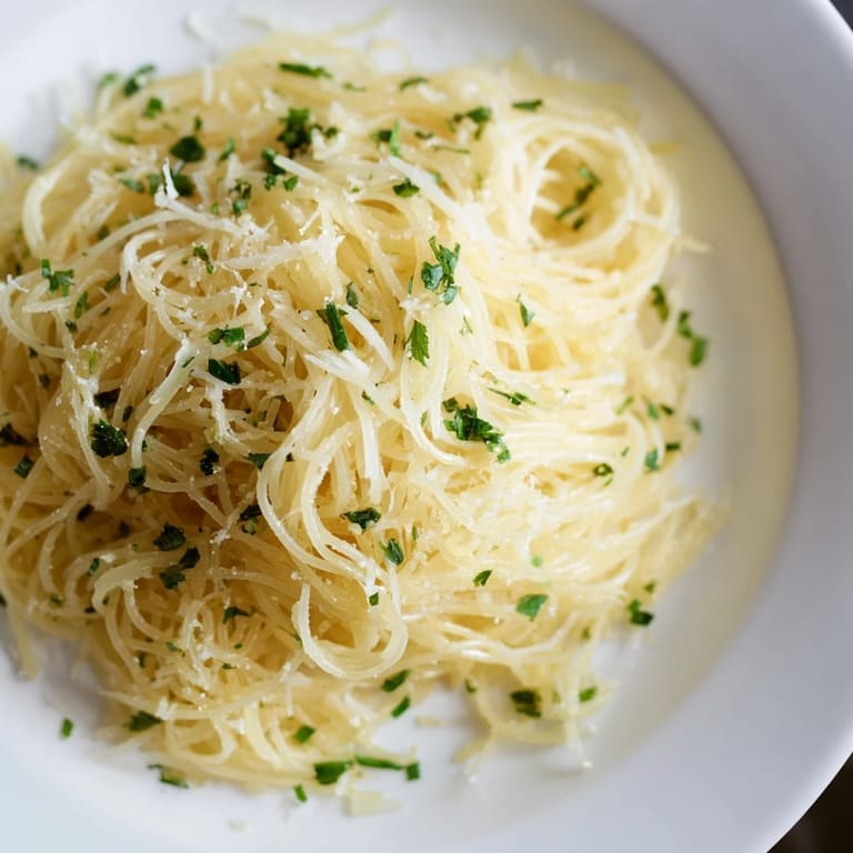 Bright and flavorful Lemon Capellini recipe, garnished with fresh herbs, ready to serve with Parmesan.